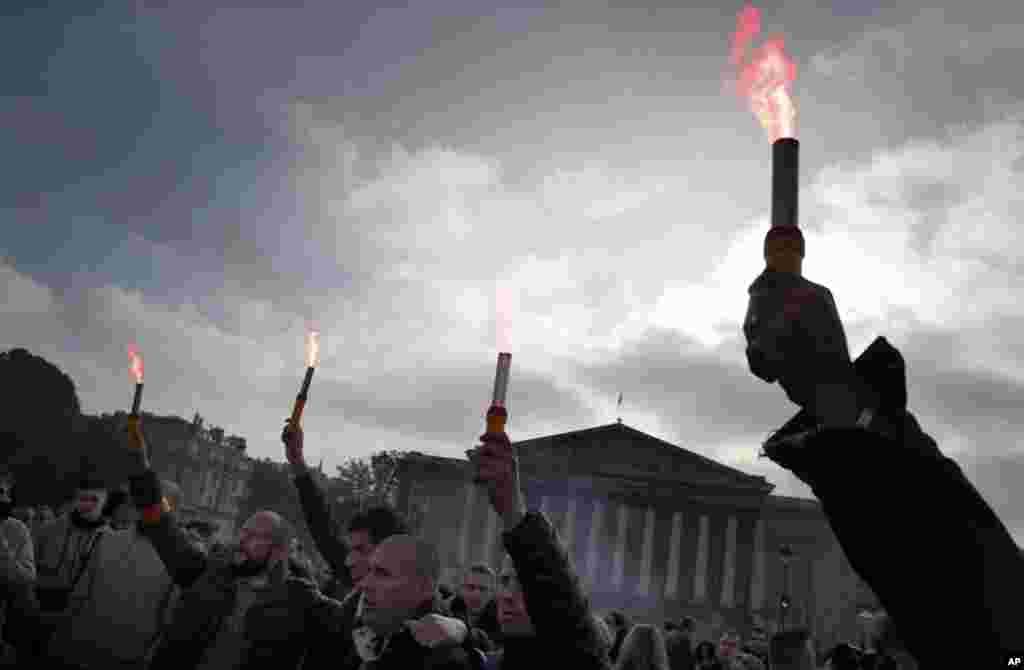 Police officers light flares during a demonstration in front of the National Assembly, in Paris, France, Oct. 26, 2016.