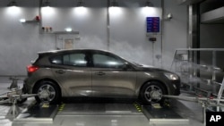 FILE - A Ford Focus is tested in heavy rain and wind in a testing room at the brand new Ford Environmental Test Center in Cologne, May 17, 2018. 