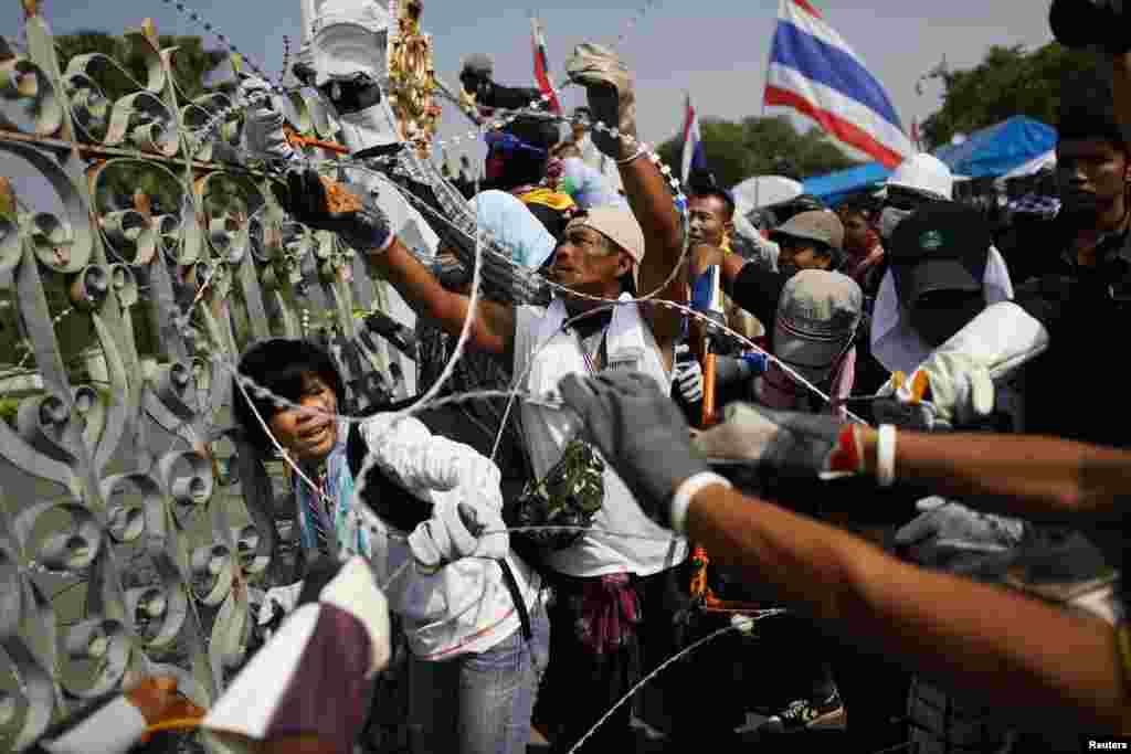 Anti-government protesters in Bangkok, Thailand remove barbed wire before a small group of them briefly entered the compound of the prime minister&#39;s office, known as the Government House.