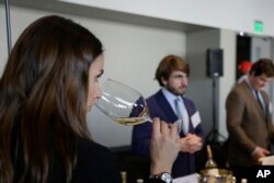 FILE: A woman tastes 2015 vintage wine tasting event January 25, 2018, in San Francisco.