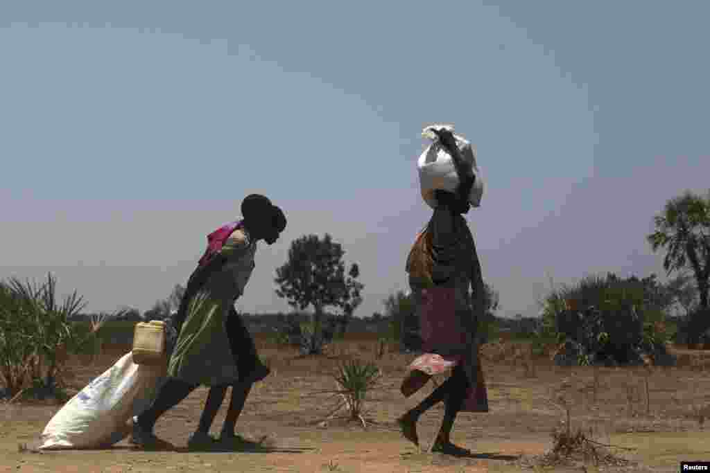 Women carry food at a food distribution site in Nyal, Unity State, April1, 2014. Women and children make up the majority of people displaced by the conflict in South Sudan.