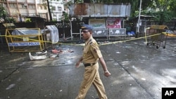 A policeman walks past the site of an explosion at Dadar in Mumbai, July 15, 2011