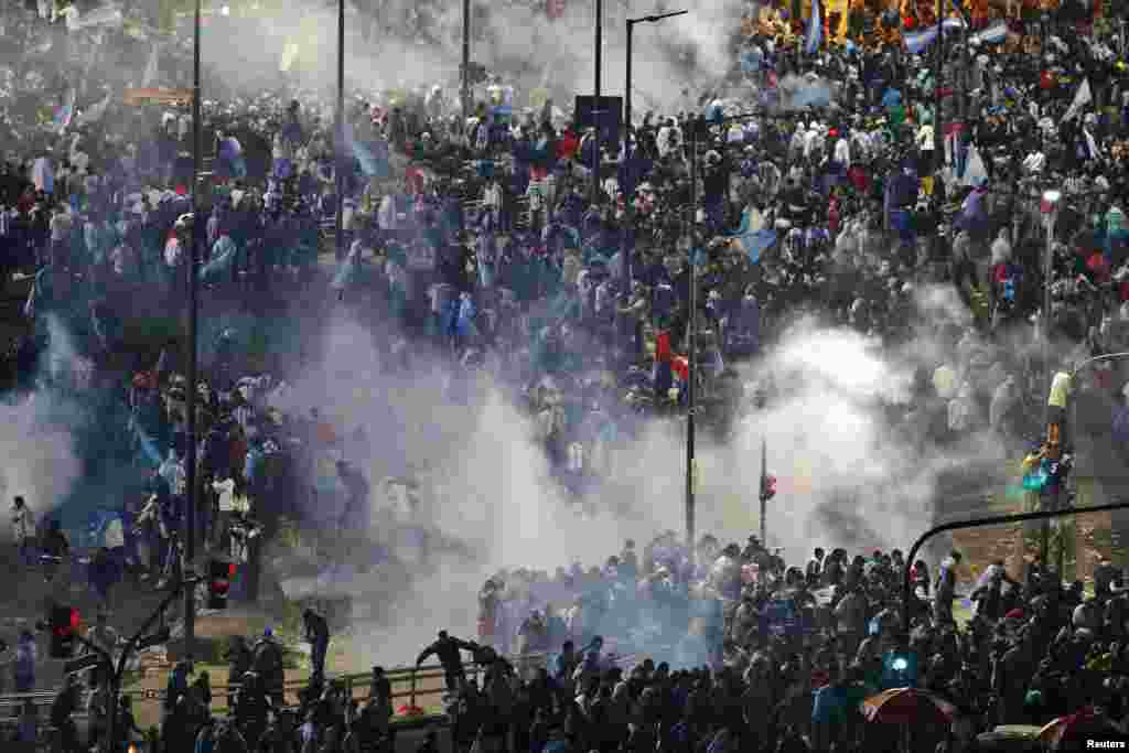Riot police use tear gas in an effort to disperse angry fans in Buenos Aires after Argentina lost to Germany in their 2014 World Cup final soccer match in Brazil, July 13, 2014.