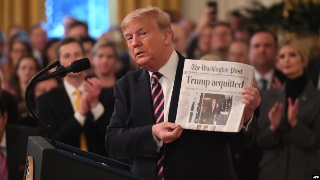 El presidente Donald Trump muestra el Washington Post con el titular "Trump absuelto" mientras habla en la Casa Blanca el jueves, 6 de febrero de 2020.