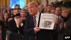El presidente Donald Trump muestra el Washington Post con el titular "Trump absuelto" mientras habla en la Casa Blanca el jueves, 6 de febrero de 2020.