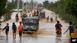 Residents wade through floodwaters fed by Typhoon Koppu at Zaragosa township, Nueva Ecija province, north of Manila, Philippines, Oct. 19, 2015. 