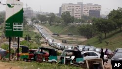 Cars queue to buy fuel at a petrol station in Abuja, Nigeria, Friday, April 1, 2016. 