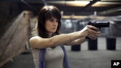 FILE - Maria Butina, a gun-rights activist, poses for a photo at a shooting range in Moscow, Russia, April 22, 2012.