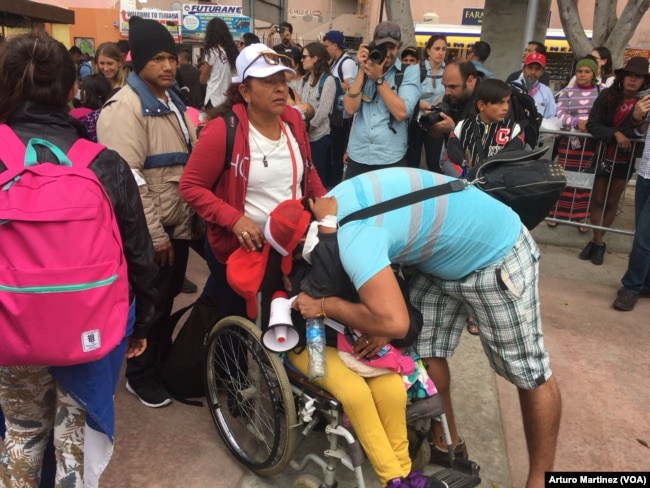 Members of the Central American migrants caravan arrive at the "El Chaparral" pedestrian crossing on their way to U.S. Customs and Border Patrol, at the U.S.-Mexico border in Tijuana, Mexico, April 29, 2018. (A. Martinez/VOA)