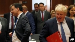 Newly appointed British Foreign Secretary Boris Johnson (R) arrives for the EU foreign ministers meeting at the EU Council building, in Brussels, Belgium, July 18, 2016.