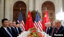 美国总统特朗普（右一）和中国国家主席习近平（左一）出席在阿根廷布宜诺斯艾利斯举行的G20领导人峰会后的工作晚宴。（2018年12月1日）
