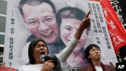 Supporters of the jailed Chinese dissident Liu Xiaobo raise the picture of him and his wife Liu Xia. (file)