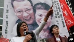 Manifestantes a favor del disidente Liu Xiaobo suben una foto con el Premio Nobel y su esposa en Hong Kong.