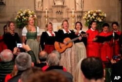 The Kroell Family Singers, center, sing "Silent Night" with the Choir of Trinity Wall Street and Trinity Youth Chorus during a celebration of the anniversary of the song at Trinity Church, Tuesday, Nov. 27, 2018, in New York.