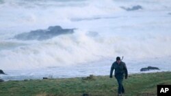 FILE - A man struggles in the strong winds in Portstewart, Northern Ireland, Jan. 29, 2016. 