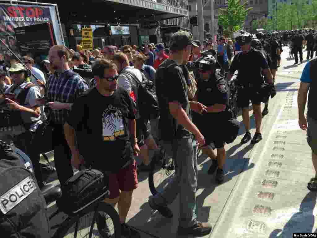 A man carrying a long rifle crosses the police line as he exits a group of Black Lives Matter activists, near Public Square, in Cleveland, July 19, 2016.