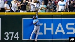 El jardinero izquierdo de los Rays de Tampa Bay, Randy Arozarena, intenta atrapar un un jonrón de Christian Walker, de los Diamondbacks de Arizona, durante la primera entrada de un partido de béisbol el martes 27 de junio de 2023 en Phoenix.