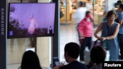 ARCHIVO: Pasajeros en una estación de trenes en Corea del Sur observan un programa de televisión que anuncia un lanzamento de misil balístico de Corea del Norte el 12 de julio de 2023.