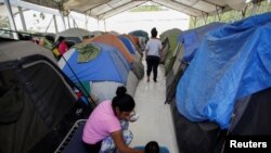 Migrantes en un campamento esperan a ser aceptados en EE.UU. desde Matamoros, México, mientras avanzaba la pandemia de coronavirus el 30 de abril de 2020.