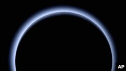 This image made available by NASA in March 2017 shows Pluto illuminated from behind by the sun as the New Horizons spacecraft travels away from it at a distance of about 120,000 miles (200,000 kilometers). On Friday, April 7, 2017, the spacecraft will reach a halfway between Pluto and its next much, much smaller stop, the Kuiper Belt object 2014 MU69. 