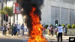 A man burns vegetation in the street after protesters went on a rampage after a court injunction stopped them from demonstrating against the economic and democratic crisis in the country, in Lilongwe, Malawi, July 20, 2011 (file photo)