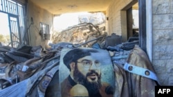 A portrait of Hezbollah chief Hassan Nasrallah sits amid destruction in an area targeted overnight by Israeli airstrikes in Saksakiyeh, Lebanon, on Sept. 26, 2024.