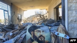 Sebuah potret Ketua Hizbullah Hassan Nasrallah tergeletak di tengah puing-puing di wilayah yang menjadi sasaran serangan udara Israel di Saksakiyeh, Kamis, 25 September 2024. (Foto: Mahmoud Zayyat/AFP)