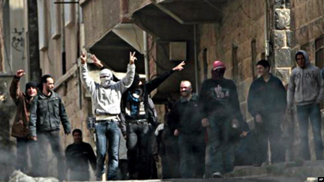 Anti-Syrian government protesters flash V sign as they protest in the southern city of Daraa, March 23, 2011