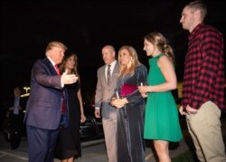President Donald Trump. left, and first lady Melania Trump greet lead pastor Jimmy Scroggins, his wife, Kristin, and their son and daughter-in-law, James, right, and Reilly as they arrive at the Family Church Downtown for a Christmas Eve service.