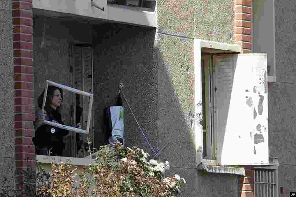 A police woman inspects the balcony of the apartment where special forces police staged the assault on the gunman Mohamed Merah, in Toulouse, March 23, 2012. (Reuters)