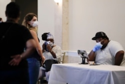 Voters wait near a polling place attendant in the Georgia's primary election at Park Tavern on Tuesday, June 9, 2020, in Atlanta. (AP Photo/Brynn Anderson)