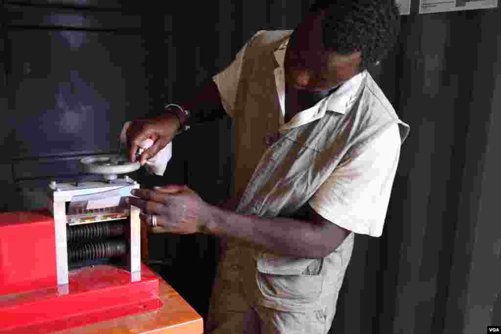 Sumani Abdul Karim uses a wire stripper at the recycling center in the Agbogbloshie neighborhood of Accra, Ghana, Oct. 27, 2014. (Chris Stein / VOA).