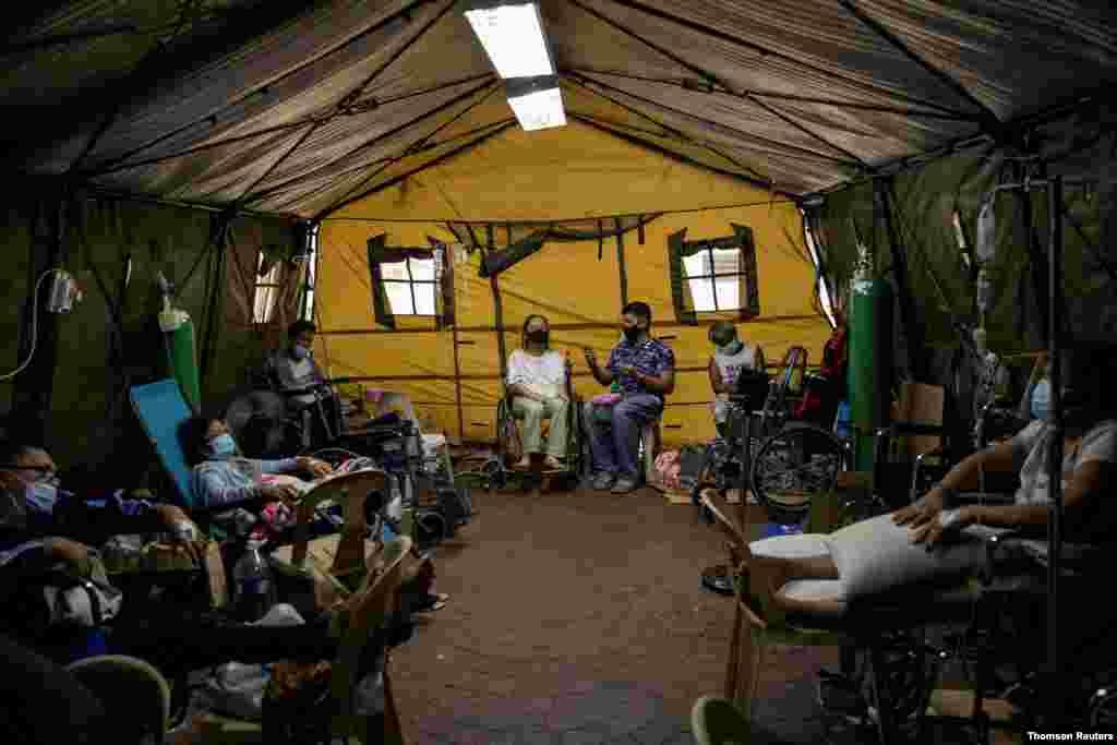 필리핀 마닐라에서 신종 코로나바이러스 확진자가 급증하면서 응급실에 병상이 부족해 환자들이 휠체어에 앉은채 치료받고 있다. 