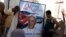 People hang up a poster with a photograph of Pope Francis in Havana, Cuba, Sept. 18, 2015. 