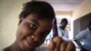 A woman shows off her inked finger after casting her ballot in Freetown, Sierra Leone, March 7, 2018. (Photo: Jason Patinkin / VOA) 