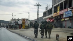 Izraelski vojnici u patroli u palestinskom gradu Hawara, koji se potpuno ispraznio nakon što je izraelska vojska zatvorila prodavnice i zabranila palestinska nakon napada palestinskih militanata i nasilja među naseljenicima u gradu, u nedjelju, 12. novembra, 2023.