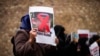 FILE - A woman holds a photograph of far-right activist Rasmus Paludan during a protest outside the Swedish consulate in Istanbul, Turkey, Jan. 28, 2023. Paludan infuriated Turkey by staging a Quran-burning protest in Sweden on Jan. 21, 2023.