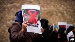 FILE - A woman holds a photograph of far-right activist Rasmus Paludan during a protest outside the Swedish consulate in Istanbul, Turkey, Jan. 28, 2023. Paludan infuriated Turkey by staging a Quran-burning protest in Sweden on Jan. 21, 2023.