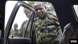 Tentara pendukung Ouattara mengamati mayat laki-laki yang tewas ditembak pendukung Laurent Gbagbo di Abidjan (7/4).