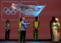 FILE - President of the International Olympic Committee Thomas Bach waves the Olympic flag in the Handover Ceremony during the Closing Ceremony during the Youth Olympic Games, Buenos Aires, Argentina, October 18, 2018.