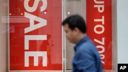 A man passes by sale signs at a shopping district in Seoul, South Korea, July 13, 2017. Bank of Korea says South Korea's economy is likely to expand 2.8 percent this year thanks to strong exports.