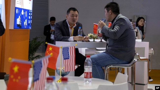 11月6號，進博會上的訪問者在一家參展的美國公司展台前面交談