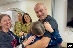 FILE —In this photo provided by the Israeli Army, Hila Rotem Shoshani, a released hostage, reunites with her uncle November 26, 2023, in Israel.