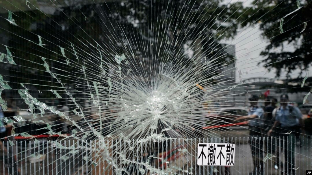 Police officers stand guard near a broken glass outside Legislative Council building in Hong Kong, July 2, 2019. 