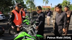 Pejabat Walikota Surabaya Nur Wiyatno memeriksa petugas Satuan Perlindungan Masyarakat (Linmas) yang akan ikut membantu pengamanan Natal dan Tahun Baru di halaman Balai Kota, Selasa, 22 Desember 2015. (VOA/Petrus Riski)