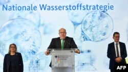 Menteri Lingkungan Hidup Jerman Svenja Schulze (kiri) dan Menteri Pembangunan Jerman Gerd Mueller (kanan) mendengarkan Menteri Ekonomi Jerman Peter Altmaier (tengah) berbicara dalam konferensi pers untuk mempresentasikan strategi hidrogen pemerintah Jerman, 10 Juni 2020. 