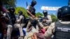 Police move detained demonstrators in the bed of a pick-up truck to a police station during a protest to demand the resignation of Haitian President Jovenel Moise in Port-au-Prince, Haiti, Feb. 7, 2021.