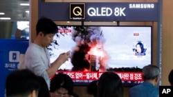 FILE - People watch a TV showing a file image of North Korea's missile launch during a news program at the Seoul Railway Station in Seoul, South Korea, Oct. 2, 2019. North Korea fired projectiles toward its eastern sea, South Korea's military said. 