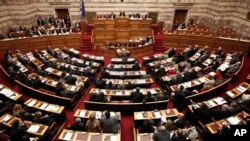 FILE - Greece's lawmakers attend a parliament session before a vote for an omnibus reforms bill in Athens, March 30, 2014. 