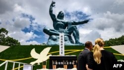 Ljudi stoje ispred Spomenika miru nakon ceremonije povodom obeležavanja 75. godišnjice bacanja atomske bombe na Nagasaki, 9. avgusta 2020.